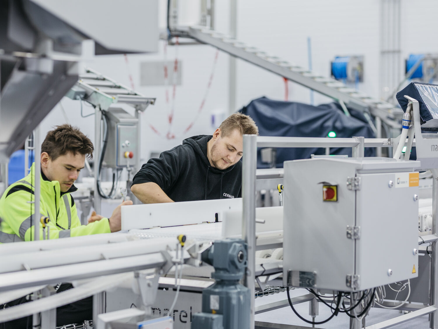 To teknikere i arbeid inne i fabrikk