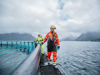 To ansatte som går på merdkanten på sjøanlegget Hellarvika